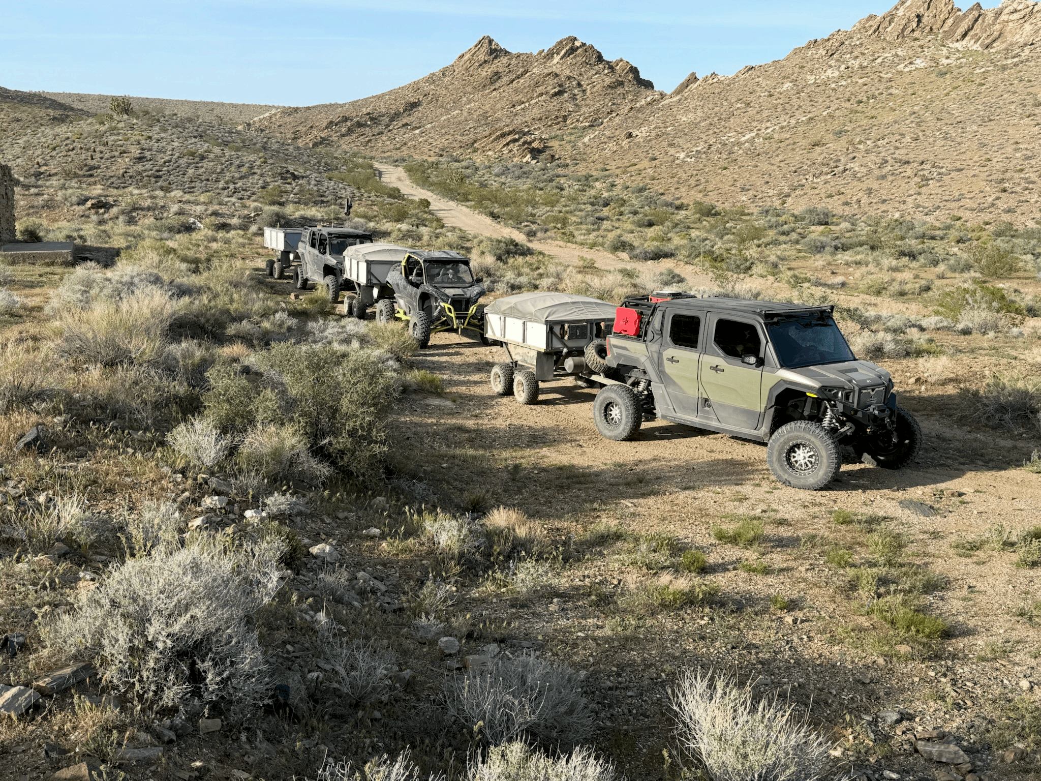 High Country Unlimited trailers and UTV convoy on a desert two-track
