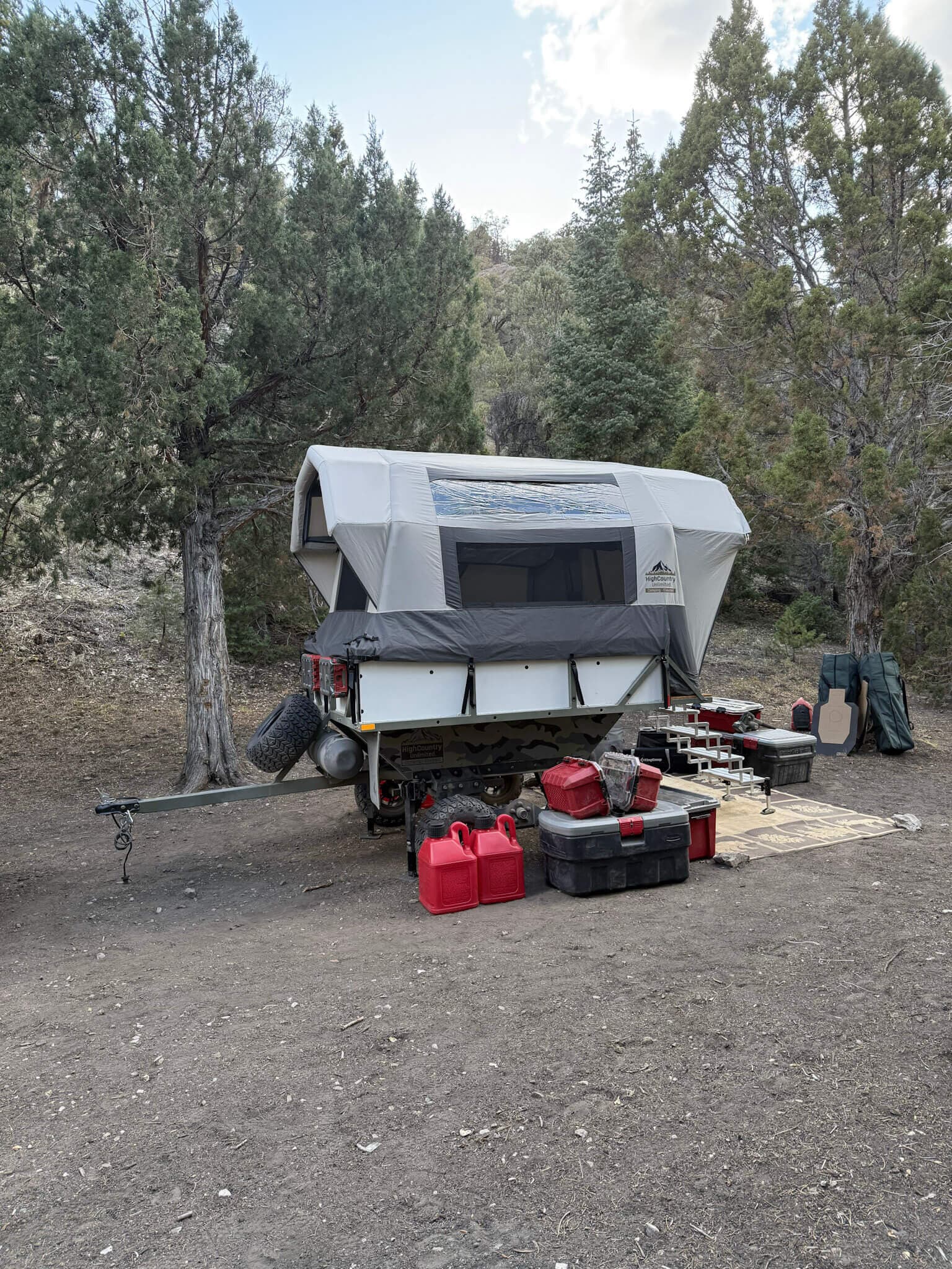 A High Country Unlimited Conestoga covered wagon camper deployed at a backcountry campsite